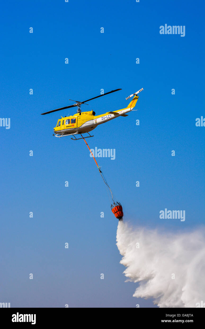 Arbeiten auf Feuer Hubschrauber Fallenlassen einer Belastung von Wasser auf das Lowveld Air Show Stockfoto