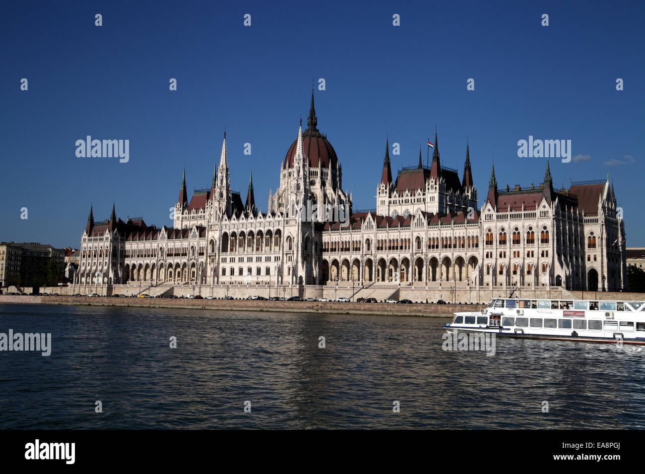 Querformat der Ungarischen Parlament unter tief blauen Himmel mit einem flussboot im Vordergrund Stockfoto