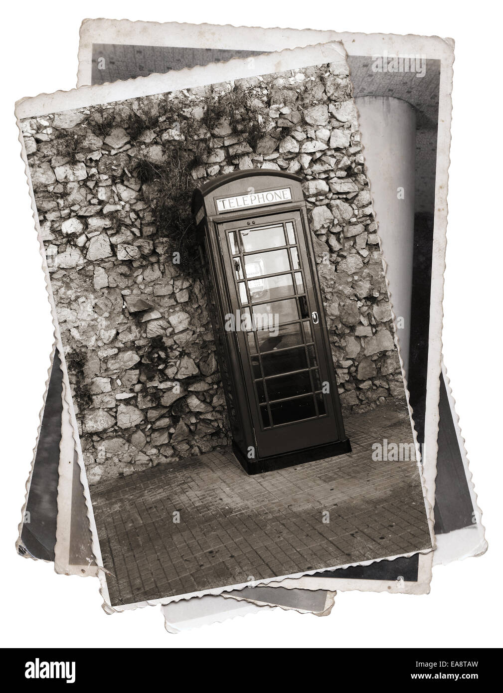 Vintage-Fotos alte Telefonzelle auf der Straße vor der Steinmauer Stockfoto