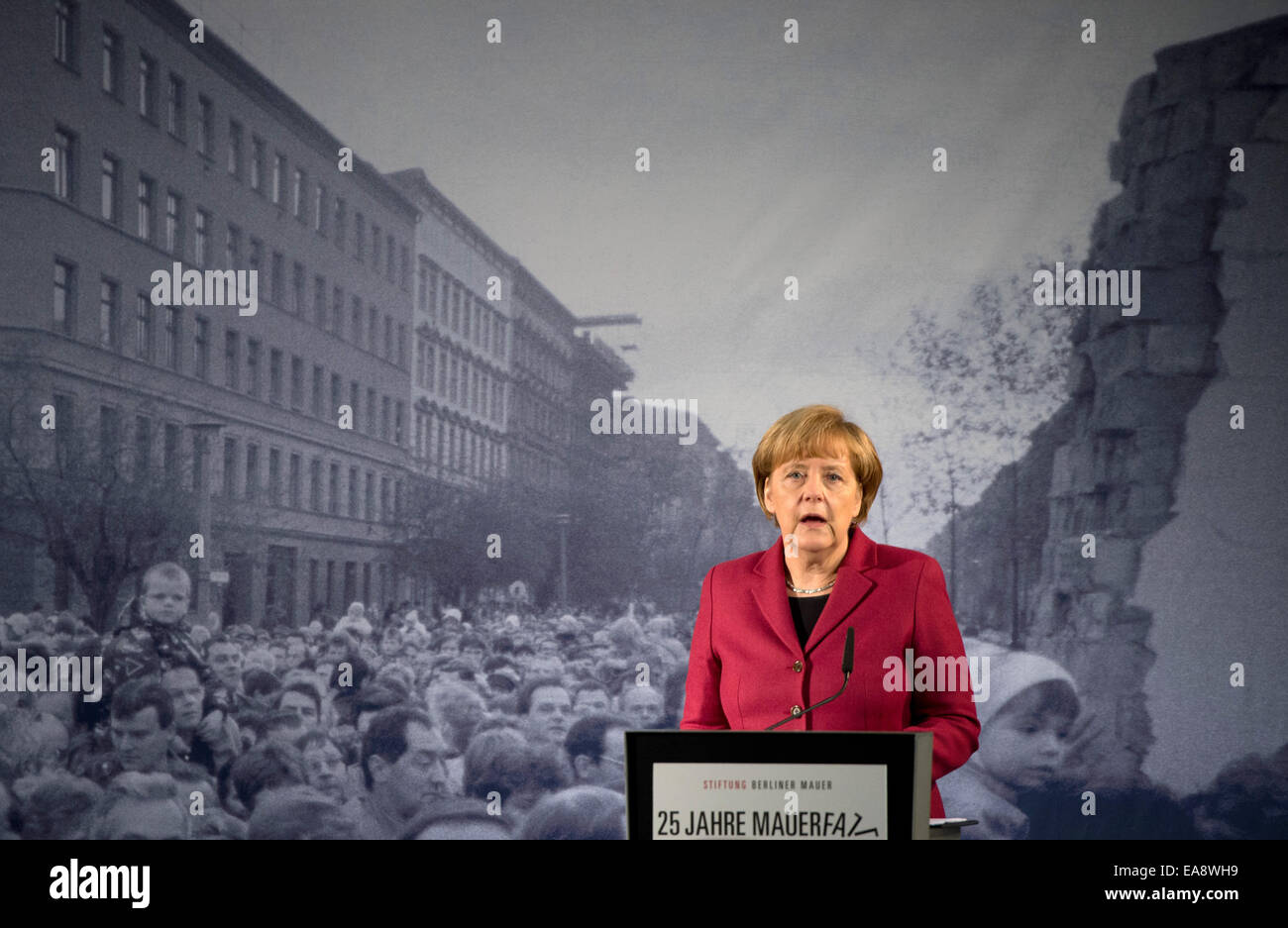 Berlin, Deutschland. 9. November 2014. Deutsche Bundeskanzlerin Angela Merkel (CDU) spricht vor einer historischen schwarz-weiß-Fotografie, Darstellung der Öffnung der Grenze an der Bernauer Straße 1989, während der zentralen Festveranstaltung des Landes Berlin und der Bundesregierung an die Berliner Mauer Gedenkstätte Bernauer Straße in Berlin, Deutschland, 9. November 2014. Zahlreiche Ereignisse markieren den 25. Jahrestag des Falles der Berliner Mauer. Foto: SOEREN STACHE/Dpa/Alamy Live News Stockfoto