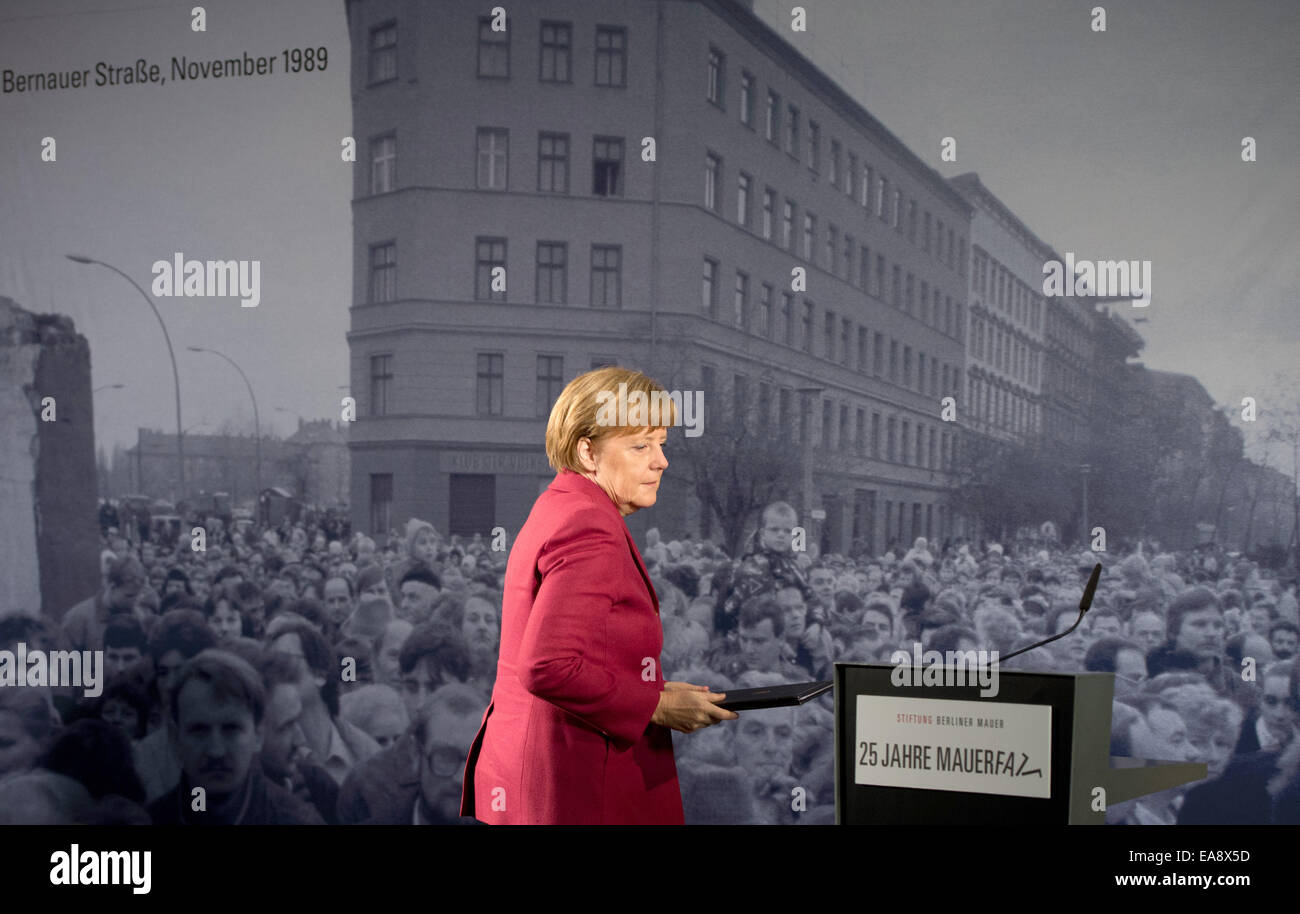 Berlin, Deutschland. 9. November 2014. Deutsche Bundeskanzlerin Angela Merkel (CDU) geht vorbei an einer historischen schwarz-weiß-Fotografie, Darstellung der Öffnung der Grenze an der Bernauer Straße 1989, während der zentralen Festveranstaltung des Landes Berlin und der Bundesregierung an die Berliner Mauer Gedenkstätte Bernauer Straße in Berlin, Deutschland, 9. November 2014. Zahlreiche Ereignisse markieren den 25. Jahrestag des Falles der Berliner Mauer. Foto: SOEREN STACHE/Dpa/Alamy Live News Stockfoto