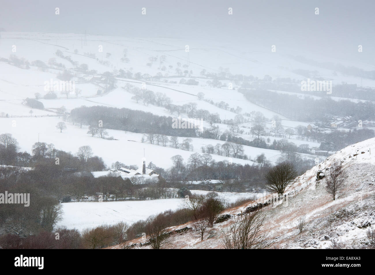 Verschneite Winterlandschaft in Nordengland. Fallender Schnee über ländliche Szene wie von Coombes Kante, Charlesworth gesehen. Stockfoto