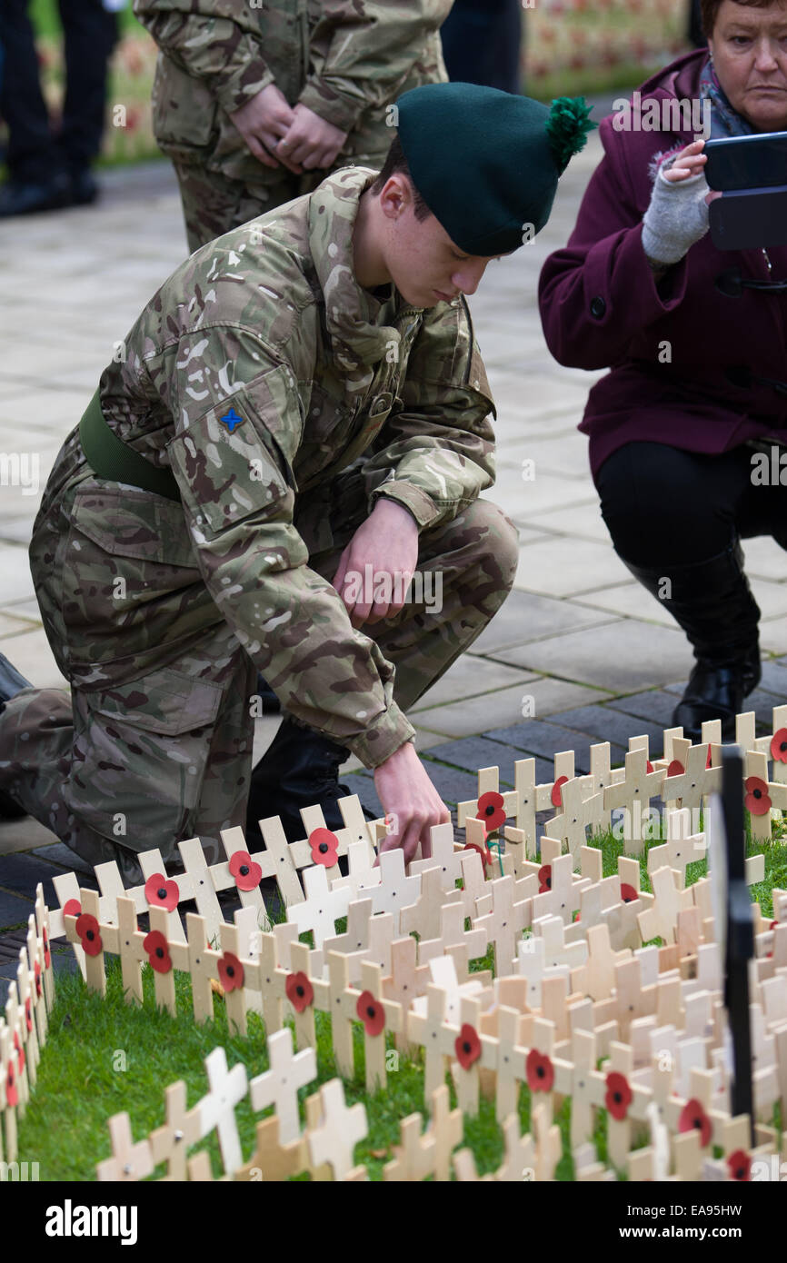 Belfast, Nordirland. 9. November 2014. Eine junge Armee-jüngstere Söhne Werke ein Holzkreuz am Cenotaph in Belfast zum Gedenken an den nationalen Tag des Gedenkens Stockfoto