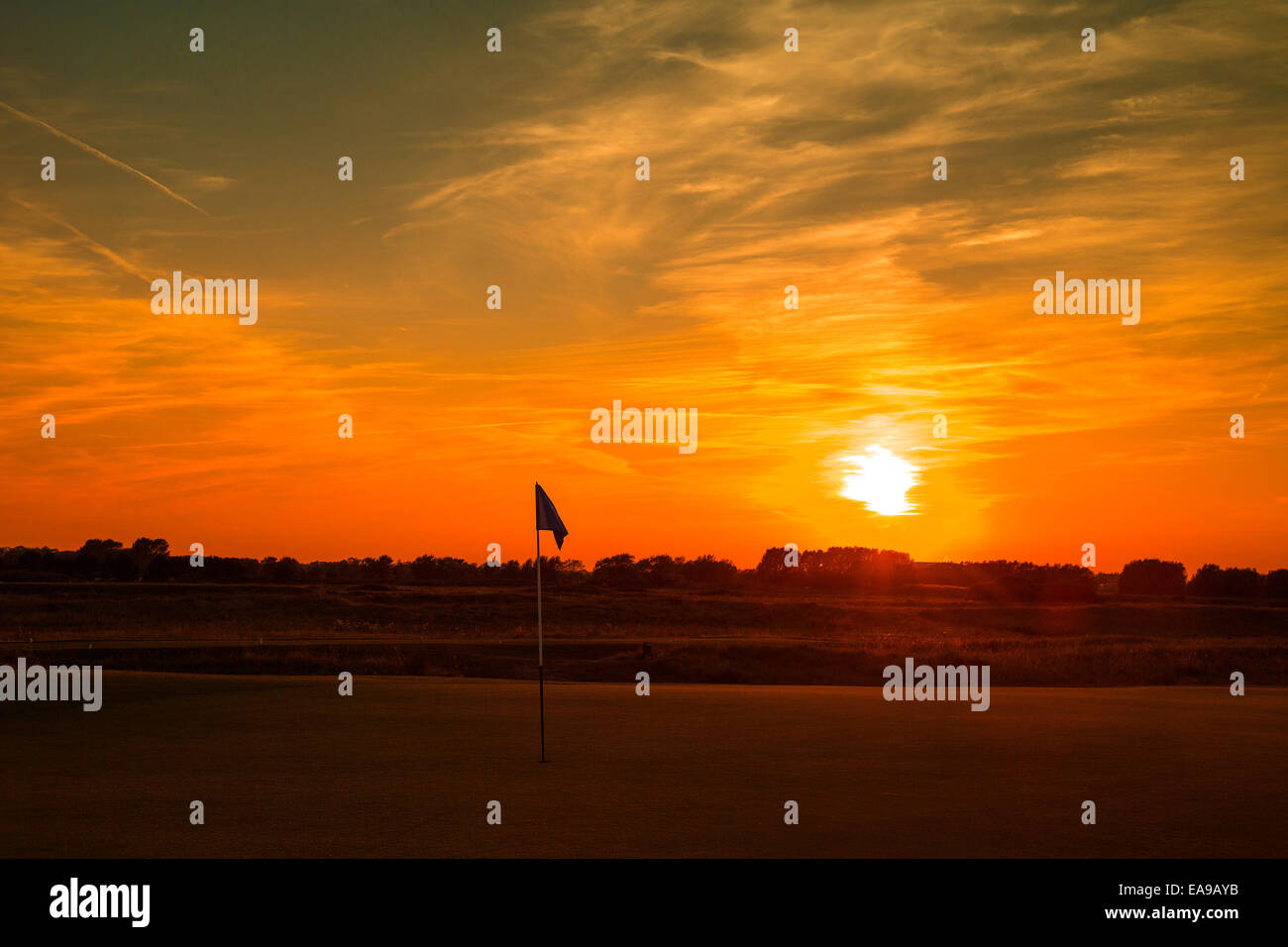 Golfflagge gegen Sonne rot Himmel über Golfplatz einstellen Stockfoto