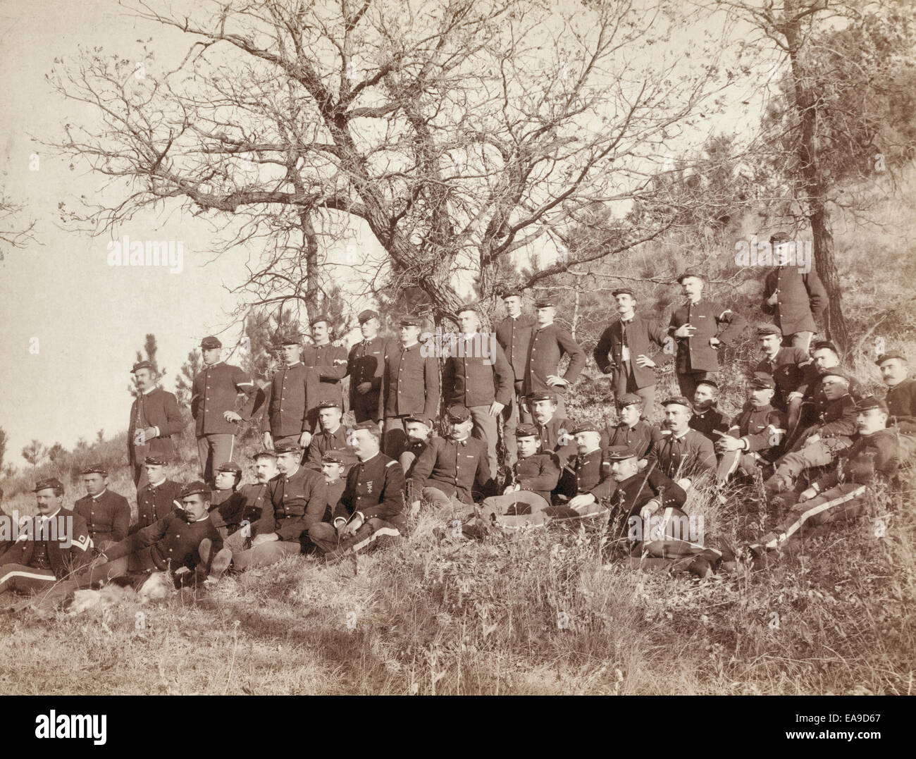 Firma "C," 3. US Infanterie nahe Fort Meade, South Dakota.  Gruppe von uniformierten Soldaten, sitzen und stehen, posierte mit Gewehre vor einem bewaldeten Hügel, um 1890 Stockfoto
