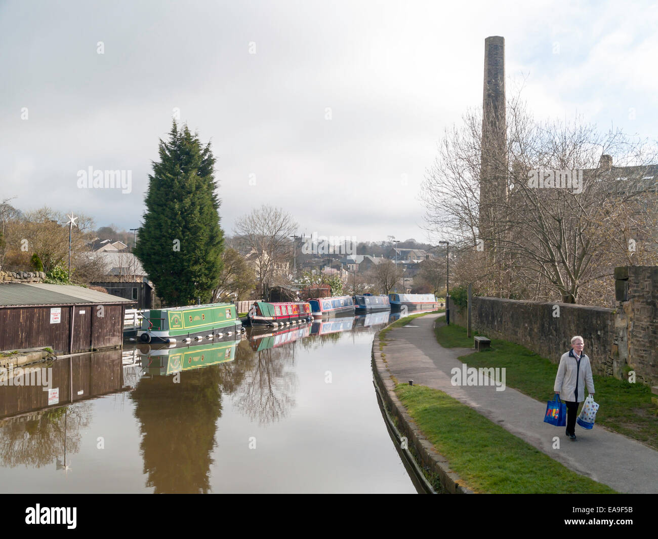 Rot Grün und blau bemalte Kanal schmale Boote vertäut auf einer Kurve in Leeds und Liverpool Kanal in Skipton West Yorkshire. Stockfoto