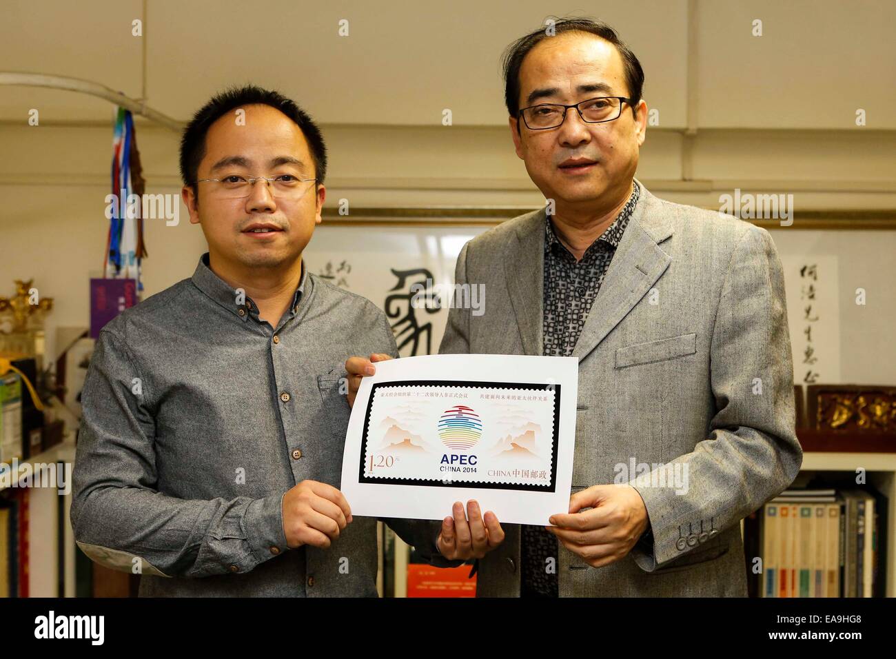 (141110)--Peking, 10. November 2014 (Xinhua)--He Jie (R) und Zhou Yue, Designer von der Sonderbriefmarke für den 22. Asien-Pazifische wirtschaftliche Zusammenarbeit (APEC) Wirtschaftsführer treffen, zeigen die Stempel-Probe in Peking, China, 4. November 2014. China Post ausgegebenen Gedenkmünze Set von einem Stempel auf der Veranstaltung am 10. November. Die commemorative Stempel hat einen Nennwert von 1,2 Yuan (ca. 20 US-Cent). (Xinhua/Zhang Yuwei) (Hdt) Stockfoto
