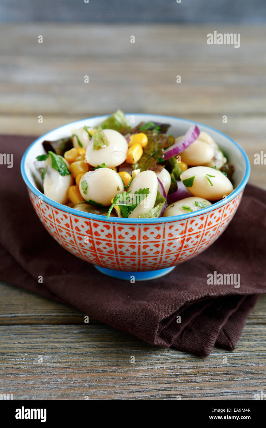 Salat mit Bohnen, Zwiebeln und Mais in eine Schüssel geben, Ernährung essen Stockfoto