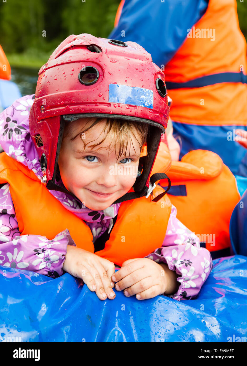Glückliche kleine Mädchen mit Helm sitzt in einem rafting-Boot Stockfoto