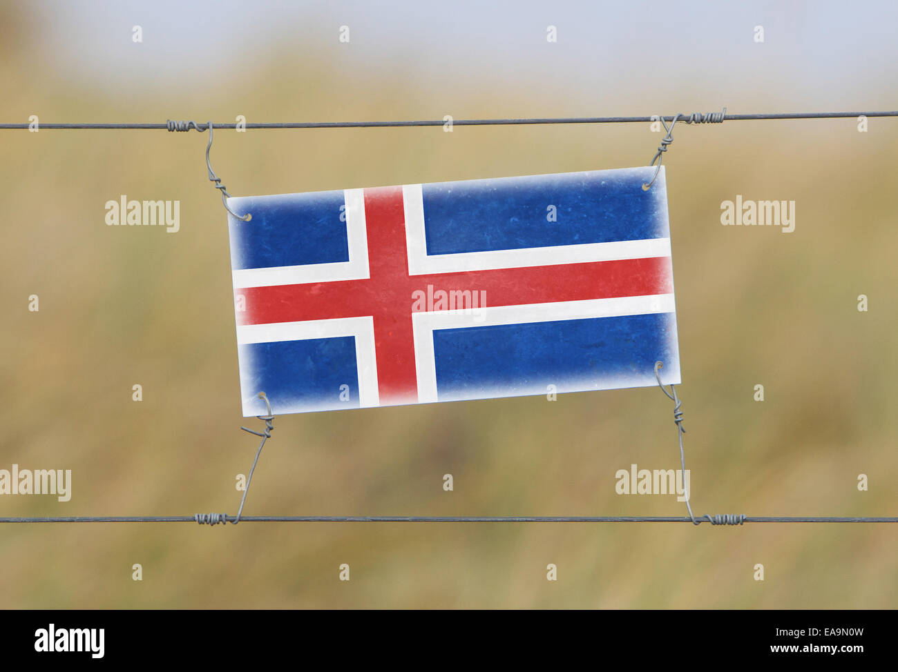 Grenze Zaun - alte Kunststoffschild mit einer Fahne - Island Stockfoto
