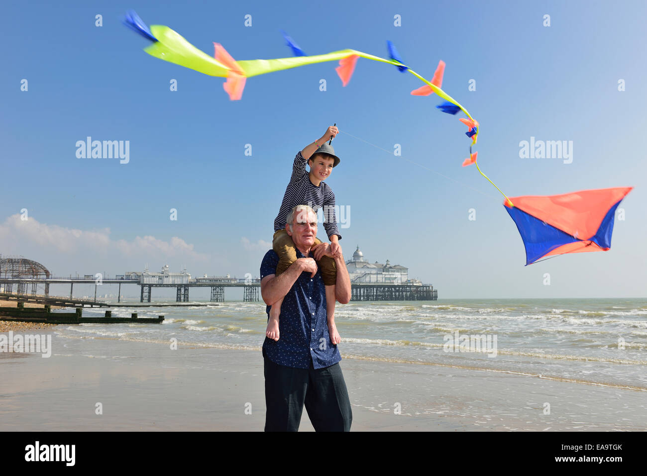 Großvater mit Enkel fliegen einen Kite am Strand von Eastbourne. East Sussex. UK Stockfoto