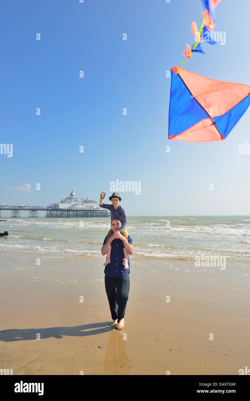 Großvater mit Enkel fliegen einen Kite am Strand von Eastbourne. East Sussex. UK Stockfoto