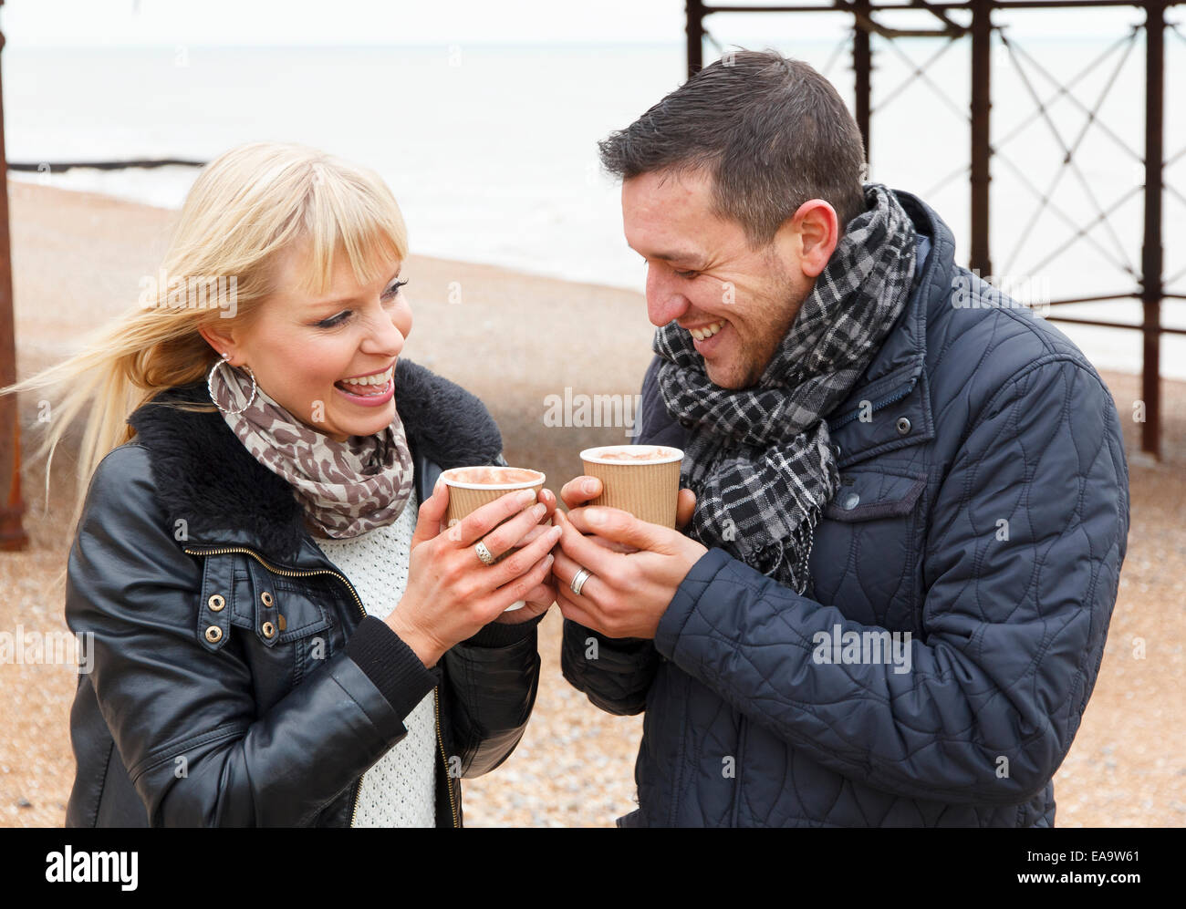 Ein paar genießt einen Tag an der britischen Küste in Brighton in warme Winterkleidung Stockfoto