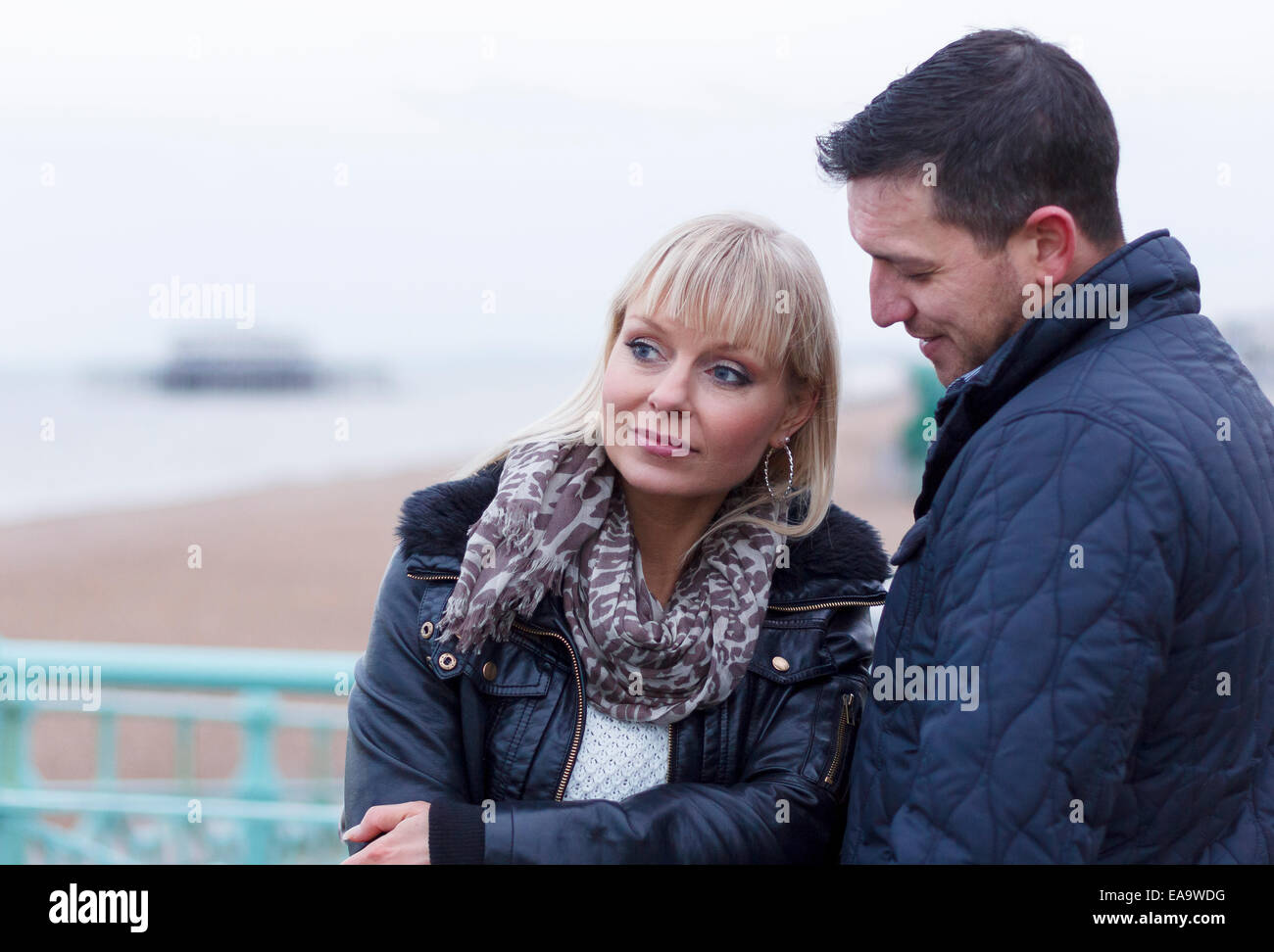 Einen nachdenklichen Moment für ein paar an einem Tag an der britischen Küste in Brighton in warme Winterkleidung Stockfoto