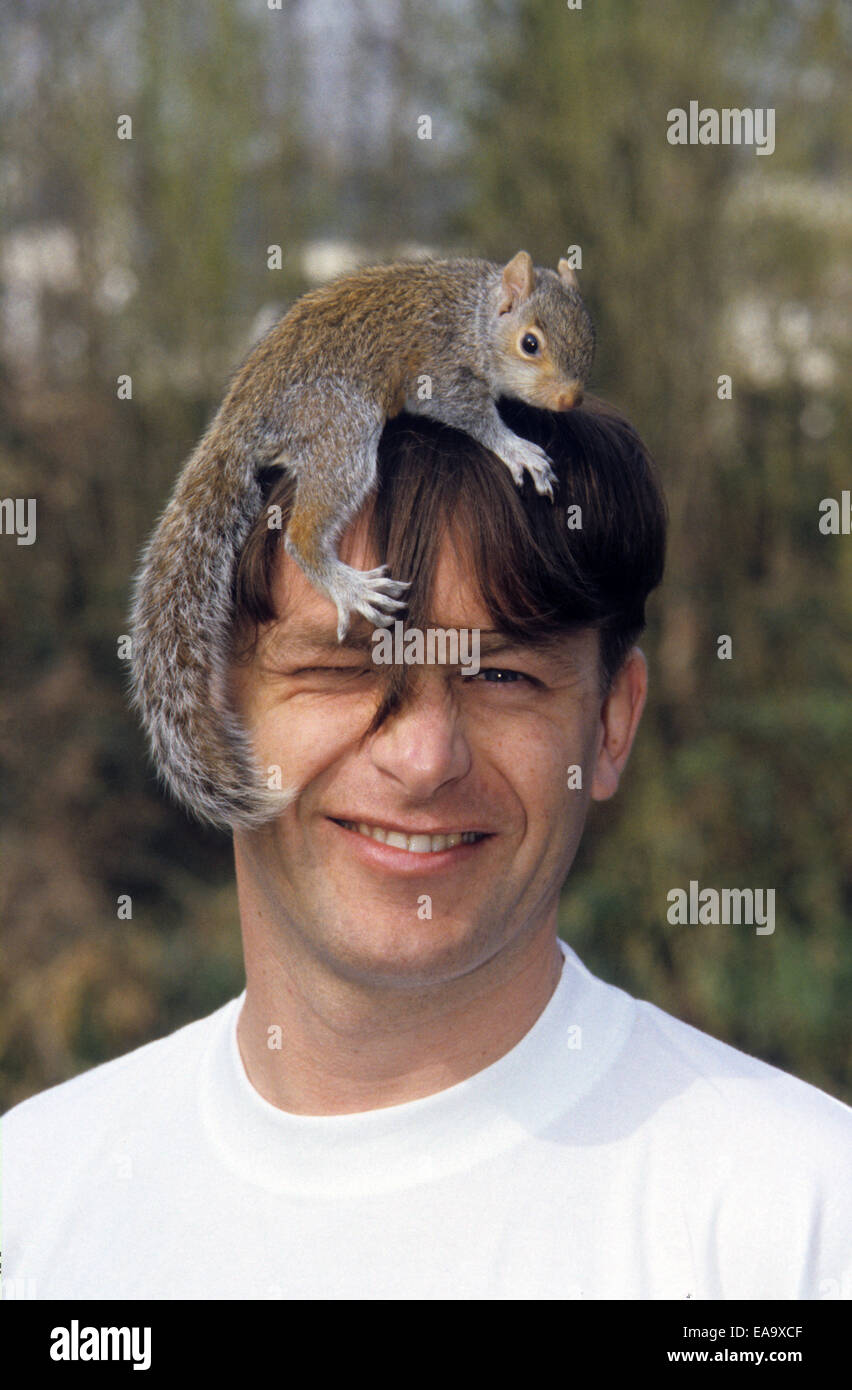 Chris Packham, TV-Moderatorin und Naturforscher fotografiert mit einem Eichhörnchen auf seinem Kopf in Holland Park London Stockfoto