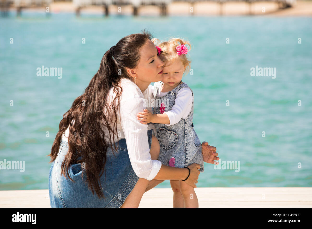 Glückliche Mama und Kind Mädchen umarmt auf Natur das Konzept von Kindheit und Familie. Schöne Mutter und ihr Baby im freien Stockfoto