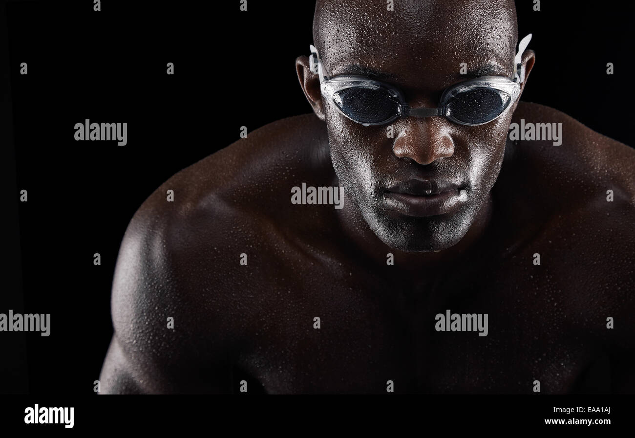 Porträt eines jungen afrikanischen Mannes tragen Schwimmbrille auf schwarzem Hintergrund isoliert. Fit junger Sportler. Stockfoto