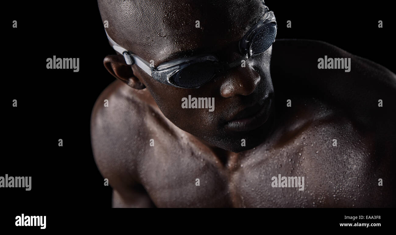 Nahaufnahme der afrikanischen Sportler beim Schwimmen Brille über die Schulter schauen. Professionelle Schwimmer auf schwarzem Hintergrund. Stockfoto