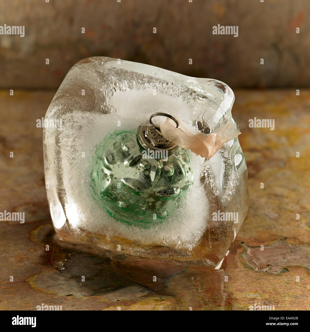 Eine Weihnachtskugel in einem schmelzenden Eisblock eingefroren Stockfoto