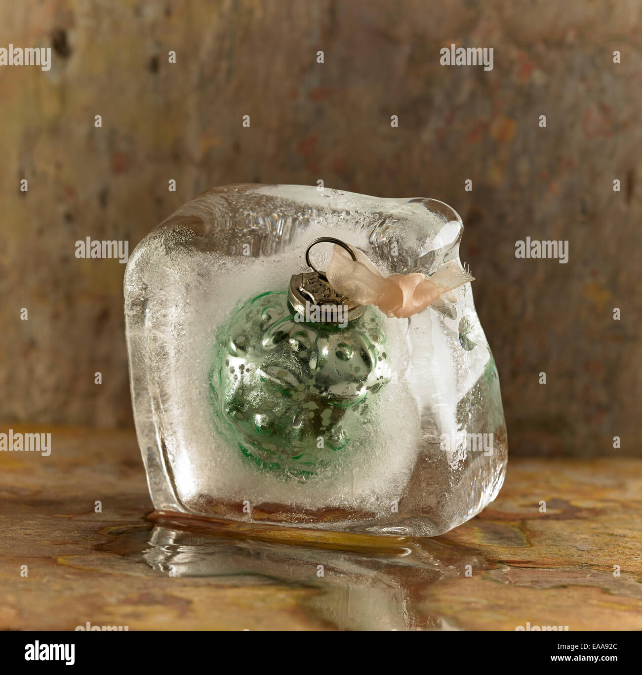 Eine Weihnachtskugel in einem schmelzenden Eisblock eingefroren Stockfoto
