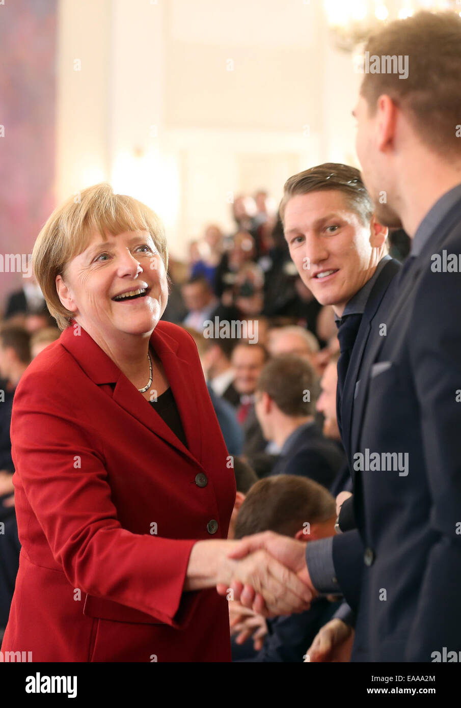 Berlin, Deutschland. 10. November 2014. Deutsche Bundeskanzlerin Angela Merkel (CDU) grüßt Nationalmannschaft Fußball-Spieler, Bastian Schweinsteiger (C) und Ron-Robert Zieler (R) im Schloss Bellevue in Berlin, Deutschland, 10. November 2014. Die deutsche Fußball-Nationalmannschaft ist mit dem Award "Silbernes Lorbeerblatt" ausgezeichnet, für den Gewinn der WM 2014 in Brasilien. Bildnachweis: Dpa picture Alliance/Alamy Live News Stockfoto