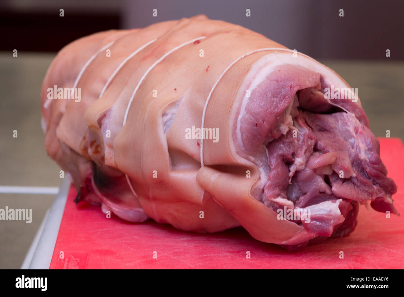 Gemeinsames Schweinefleisch auf einem roten Schneidebrett rohes Fleisch Stockfoto