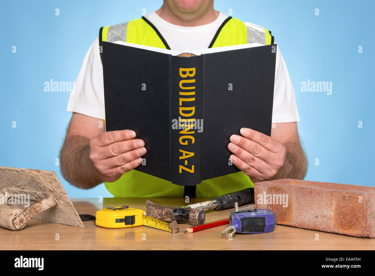 Ein Baumeister saß an einem Schreibtisch, einem Gebäude A-Z Buch Stockfoto