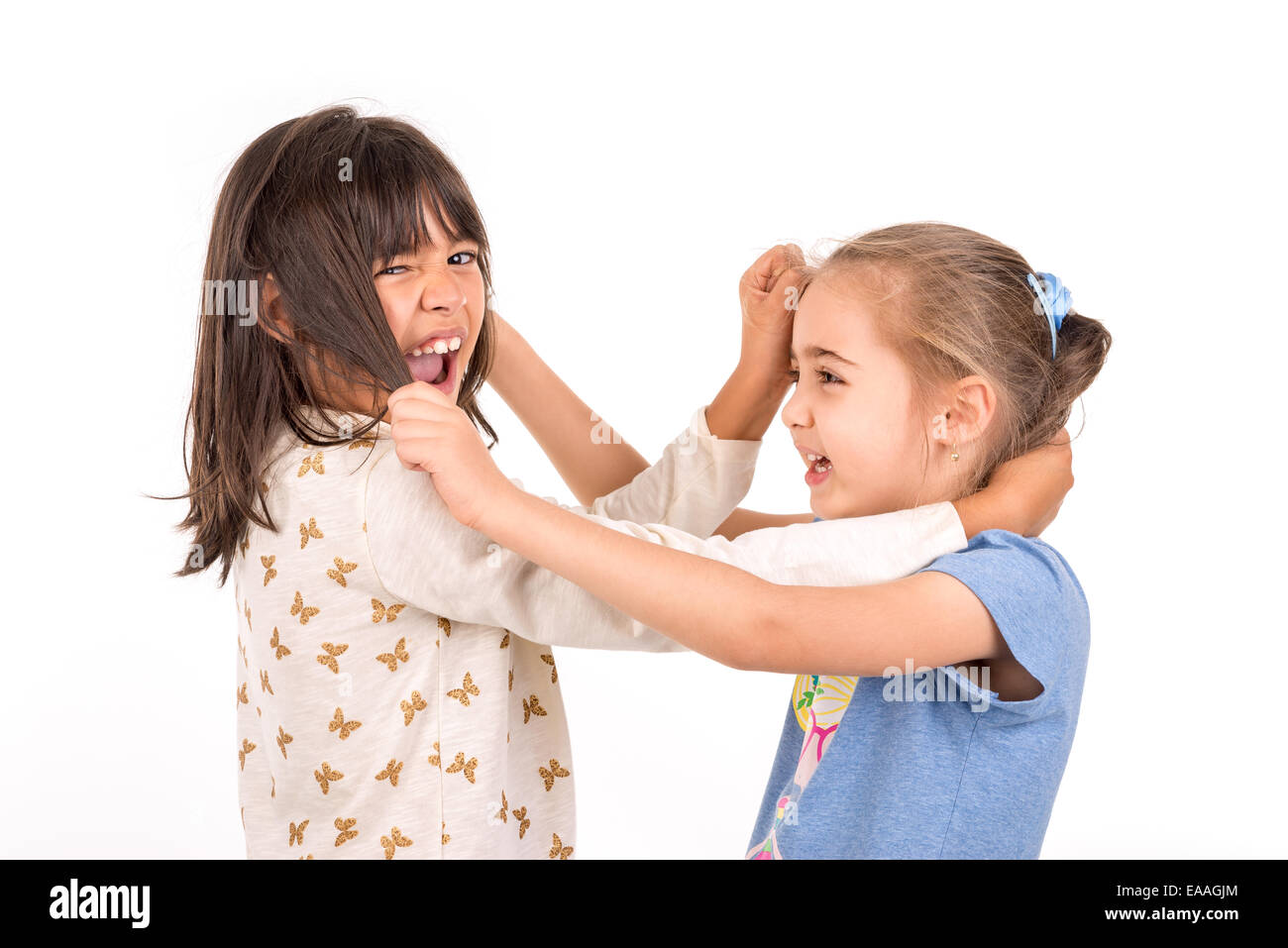 Junge Mädchen kämpfen, ziehen Haare isoliert in weiß Stockfoto