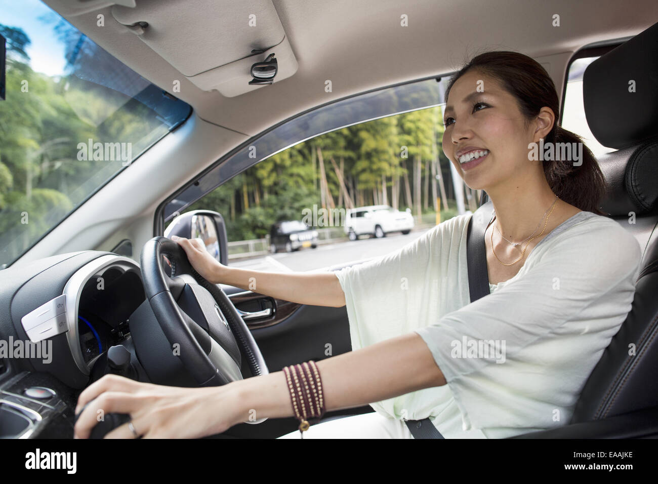 Eine junge Frau sitzt in ihrem Auto. Stockfoto