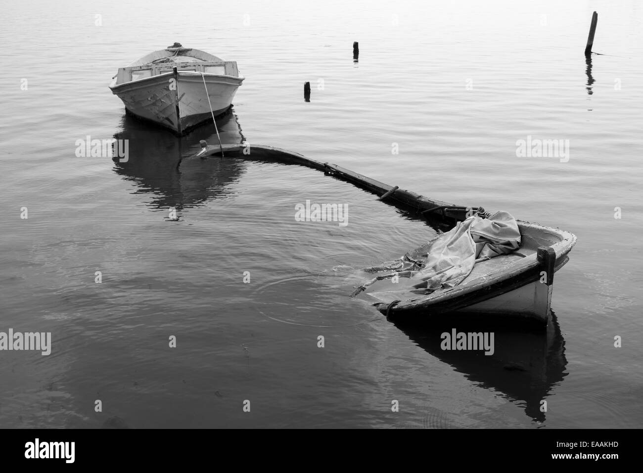 Versunkene Angeln Boot Reflexion über die See schwarz und weiß Stockfoto