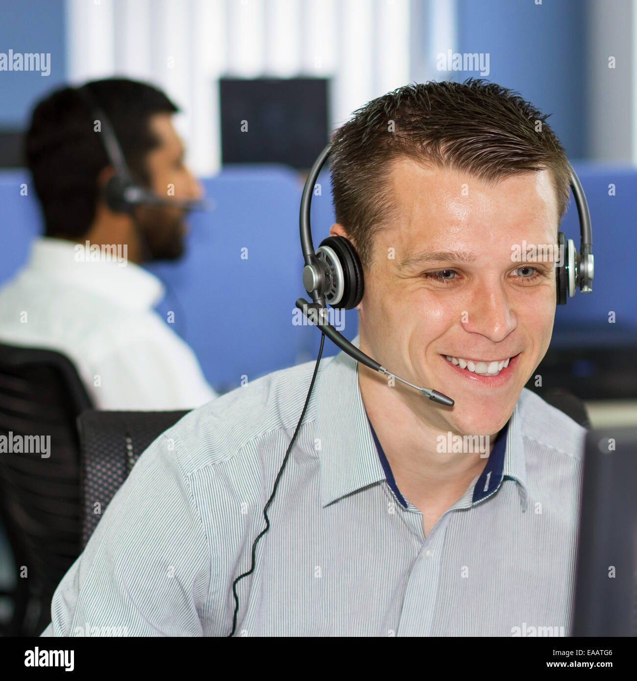 Call Center - 20er Jahre junge Männer tragen audio Kopfhörer im Telemarketing-Zentrum Stockfoto