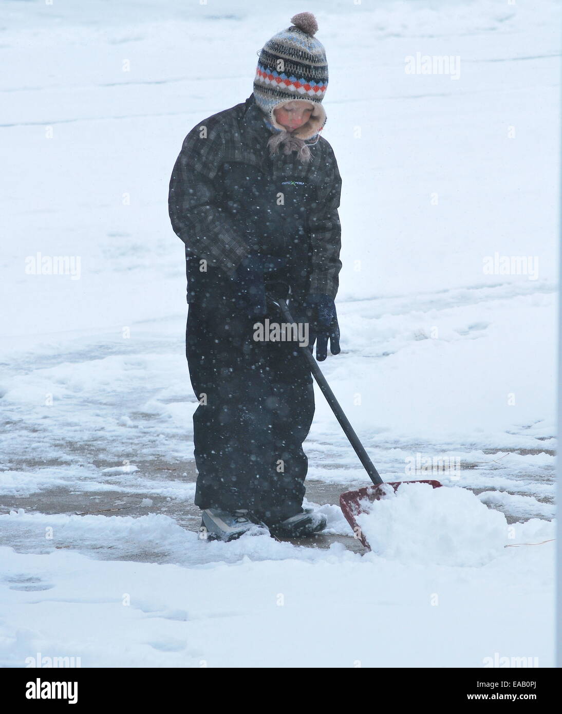 Mädchen Schaufeln Schnee draußen. Stockfoto