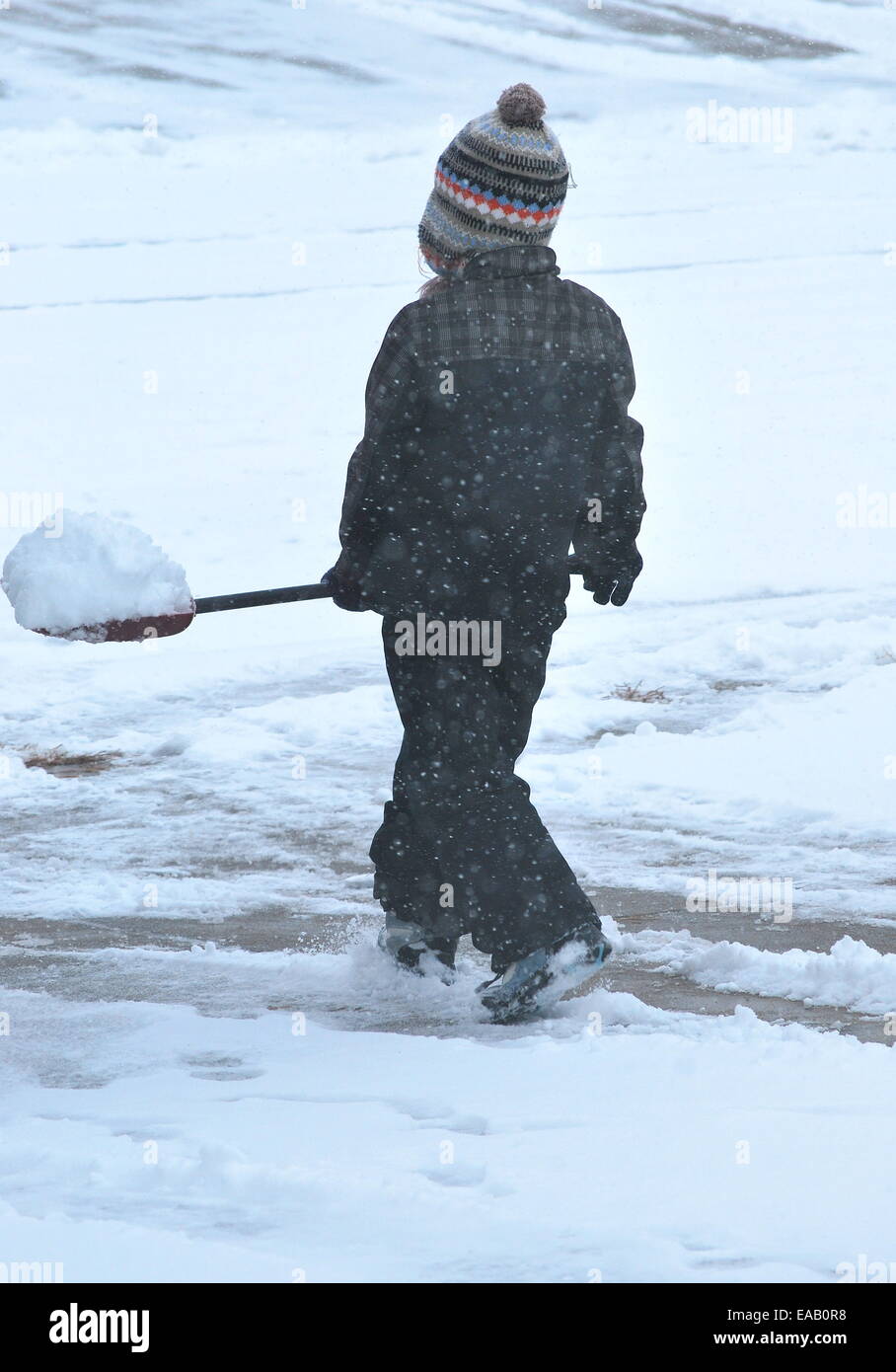 Mädchen Schaufeln Schnee draußen. Stockfoto