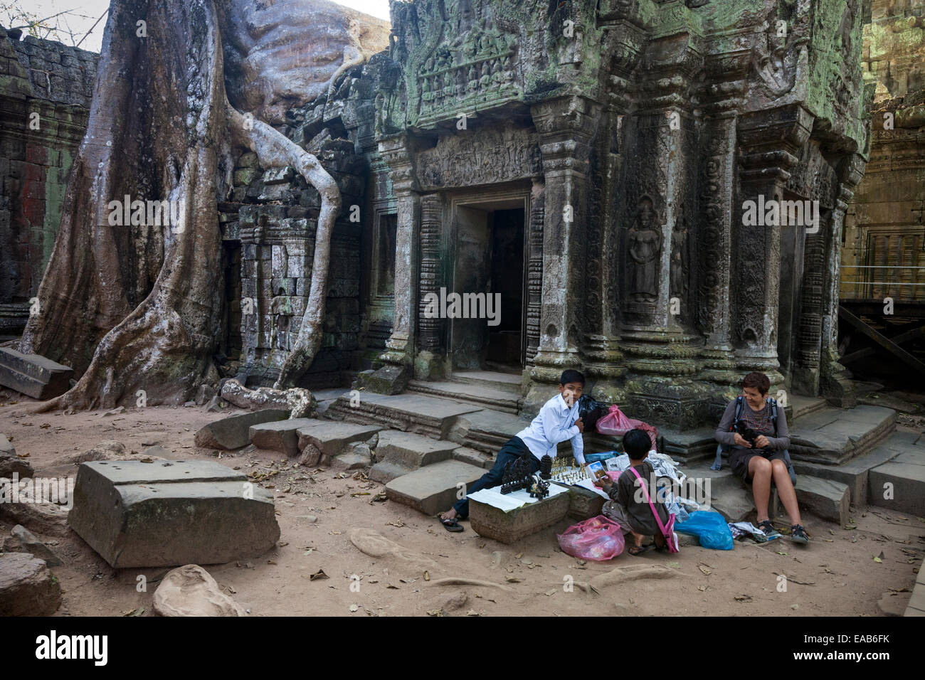 Kambodscha.  Ta Prohm Tempel Ruinen, 12.-13.. Jahrhundert.  Jungen mit Souvenirs, Schmuck und Postkarten. Stockfoto