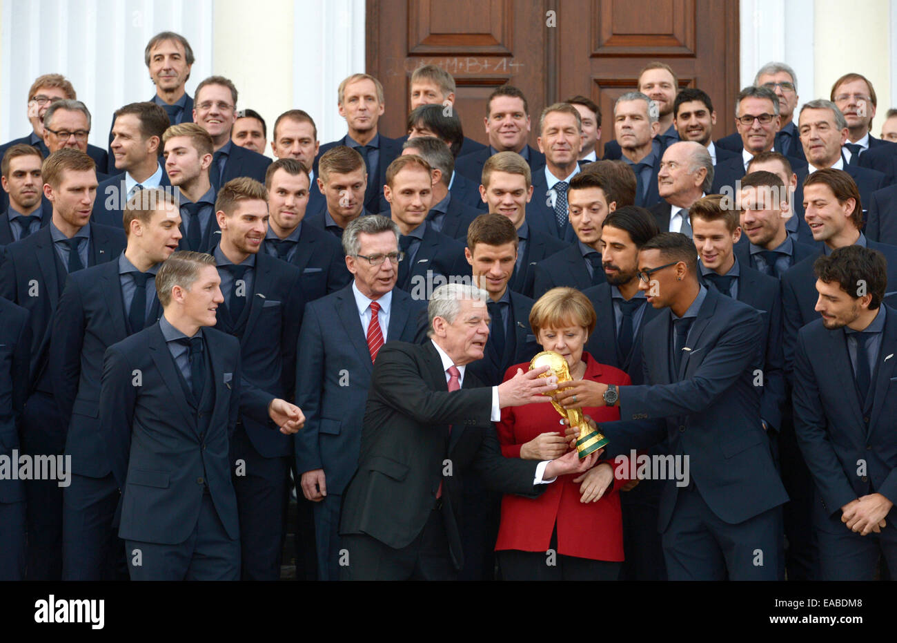 Berlin, Deutschland. 10. November 2014. Der deutsche Bundespräsident Joachim Gauck, Bundeskanzlerin Angela Merkel und Minister des Innern Thomas de Maziere stehen zusammen mit den 23 Fußball-Weltmeister vor Schloss Bellevue in Berlin, Deutschland, 10. November 2014. Die deutsche Fußball-Nationalmannschaft ist mit dem Award "Silbernes Lorbeerblatt" ausgezeichnet, für den Gewinn der WM 2014 in Brasilien. Foto: RAINER JENSEN/Dpa/Alamy Live-Nachrichten Stockfoto