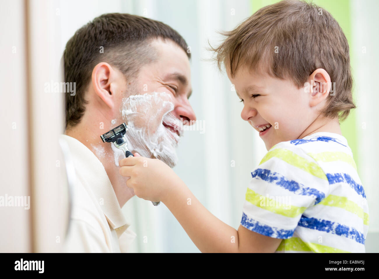Kind Junge versucht, seinen Vater zu rasieren Stockfoto