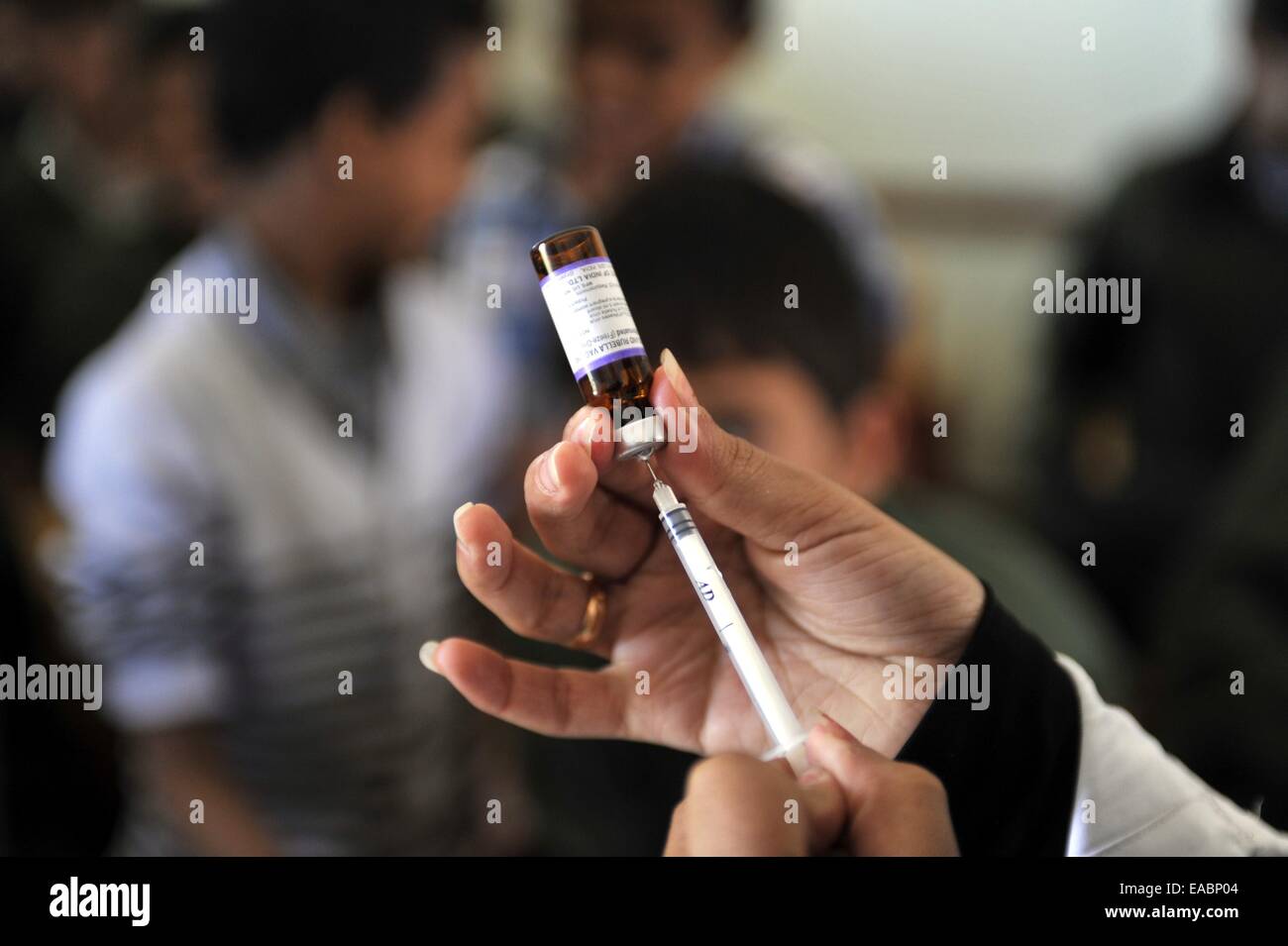 Sanaa, Jemen. 11. November 2014. Ein jemenitischer medizinische Arbeiter bereitet sich auf ein Kind eine Polio-Impfstoff Injektion während eine Impfkampagne auf 11,6 Millionen Kinder im Alter zwischen einem und fünfzehn Jahre alt, in Sanaa, Jemen, am 11. November 2014 geben. © Hani Ali/Xinhua/Alamy Live-Nachrichten Stockfoto