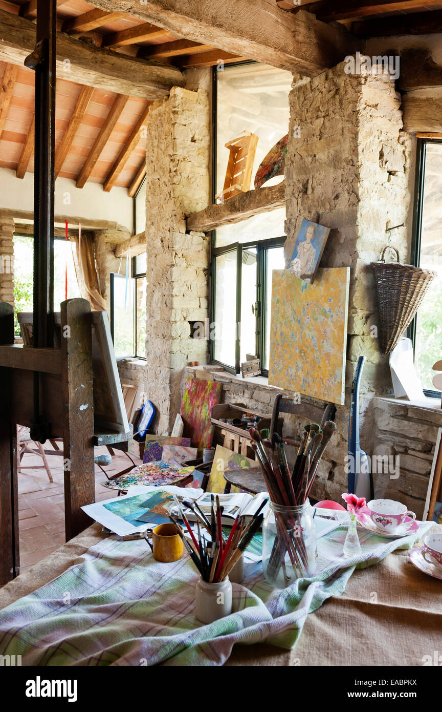 Gläser gefüllt mit Pinsel in rustikalen Künstleratelier Stockfoto