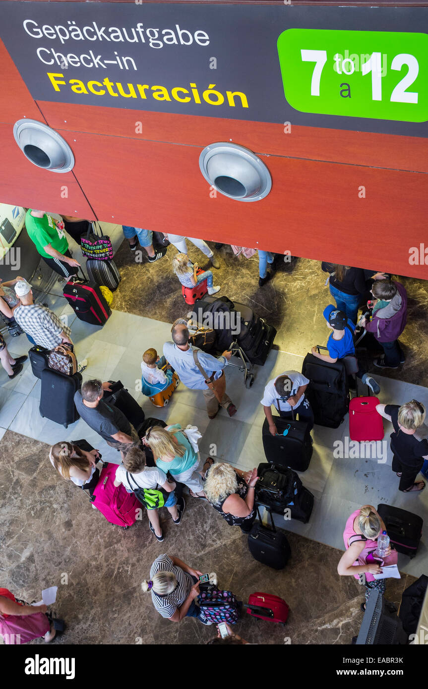 Passagiere, die Schlange, um check-in für Abflüge am Tenerife Sur Flughafen, Teneriffa, Kanarische Inseln, Spanien. Stockfoto