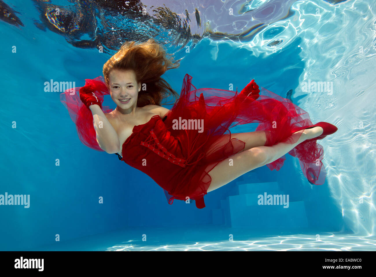 Mädchen im roten Kleid unter Wasser Stockfoto