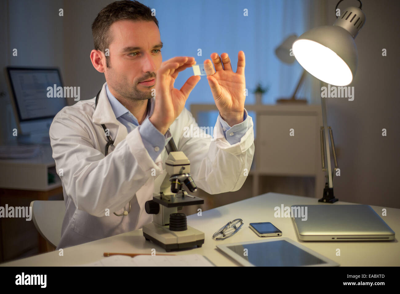 Blick auf einen jungen attraktiven Wissenschaftler arbeiten spät im Büro Stockfoto