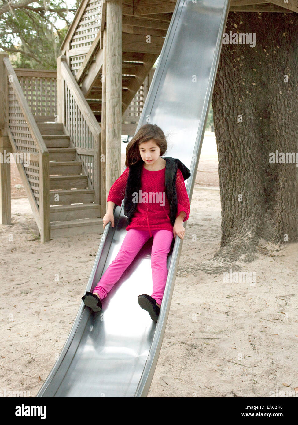 junges Mädchen auf Folie auf Spielplatz Stockfoto