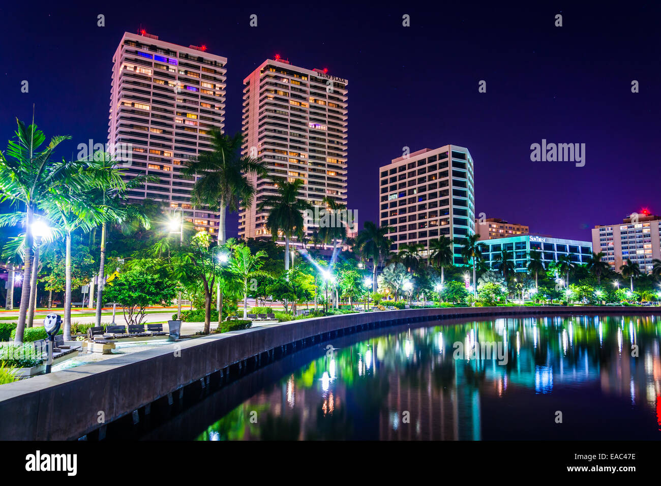 Palmen auf den Intracoastal Waterway und die Skyline bei Nacht in West Palm Beach, Florida. Stockfoto