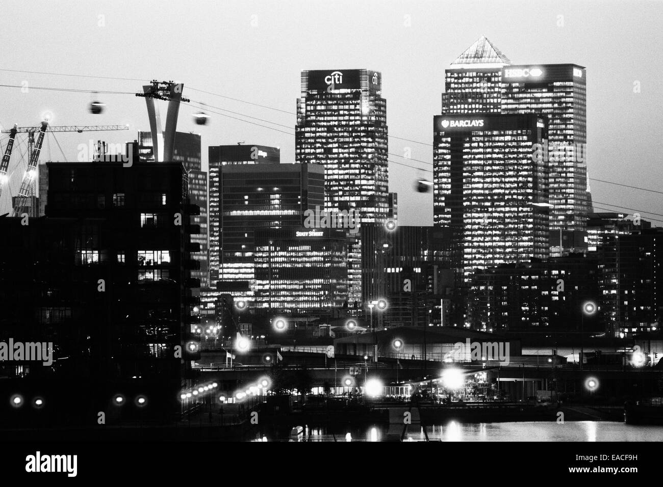 Canary Wharf, London, Großbritannien, beleuchtete in den frühen Abend mit der Emirates Seilbahnen im Vordergrund Stockfoto