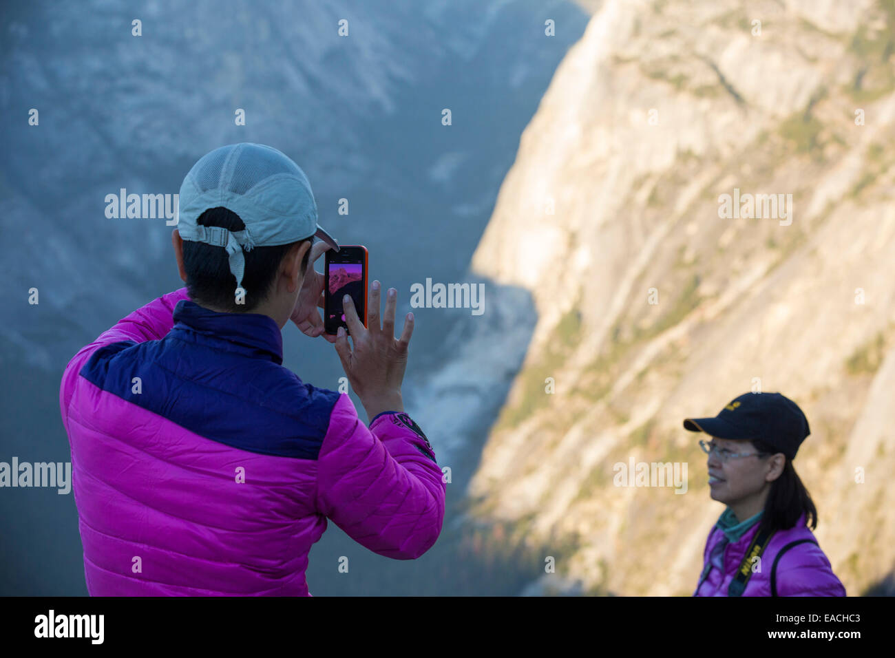 Touristen in der Abenddämmerung auf Glacier Point über Yosemite Valley, Kalifornien, USA mit Blick auf den Half Dome. Stockfoto