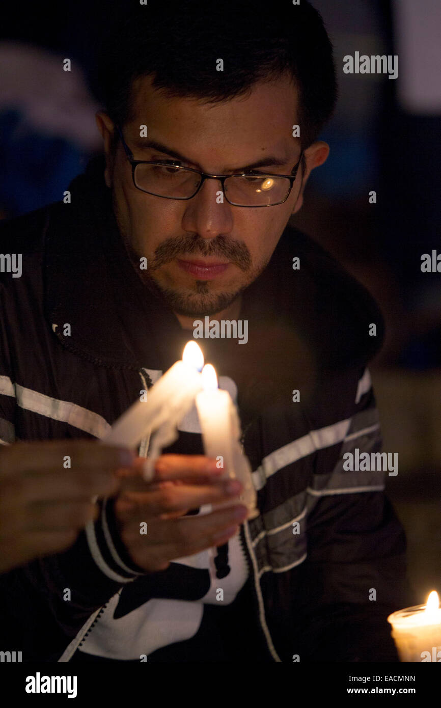 Mexico City, Mexiko. 11. November 2014. Ein Bewohner zündet eine Kerze während der Rallye "11.11 Light für Mexiko", in dem Engel der Unabhängigkeit in Mexiko-Stadt, Hauptstadt von Mexiko, am 11. November 2014. Laut Lokalpresse hat "Kette des Lichts" das Ziel, die Gewalt in Mexiko, im Rahmen der Aktionen zu verurteilen, dass die Nachfrage der lebendig Präsenz der 43 Schüler von der ländlichen der Normal Ayotzinapa, das in Iguala, Guerrero vermisst. © Alejandro Ayala/Xinhua/Alamy Live-Nachrichten Stockfoto