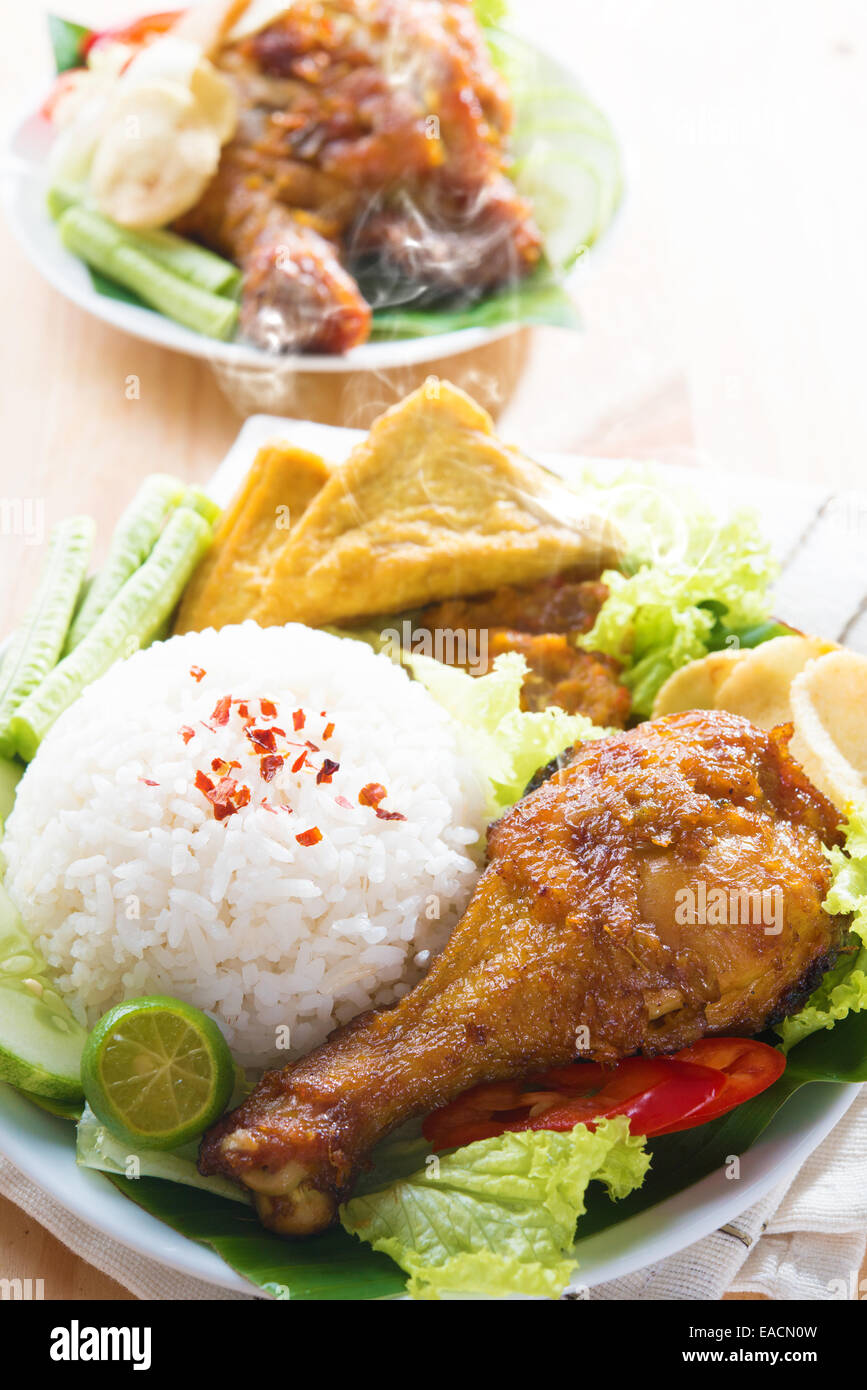 Berühmte traditionelle Malaiische Küche. Köstliches Nasi Ayam Penyet mit Sambal Belacan. Lokalkolorit. Frisch heiß mit Dampf Rauch. Stockfoto