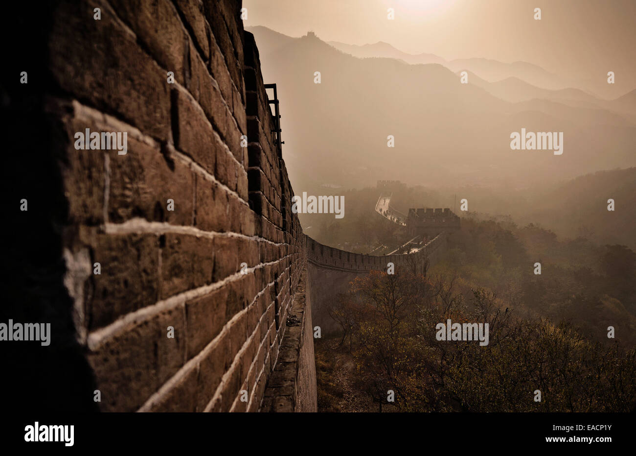 Die Great Wall Of China erhebt sich bei Sonnenuntergang über die umliegende Landschaft bedeckt durch Smog bei Badaling, einige 70kilometers nordwestlich von Peking in Yanqing County, China. Die große Mauer erstreckt sich über die historischen Nordgrenze Chinas und damit die Stockfoto