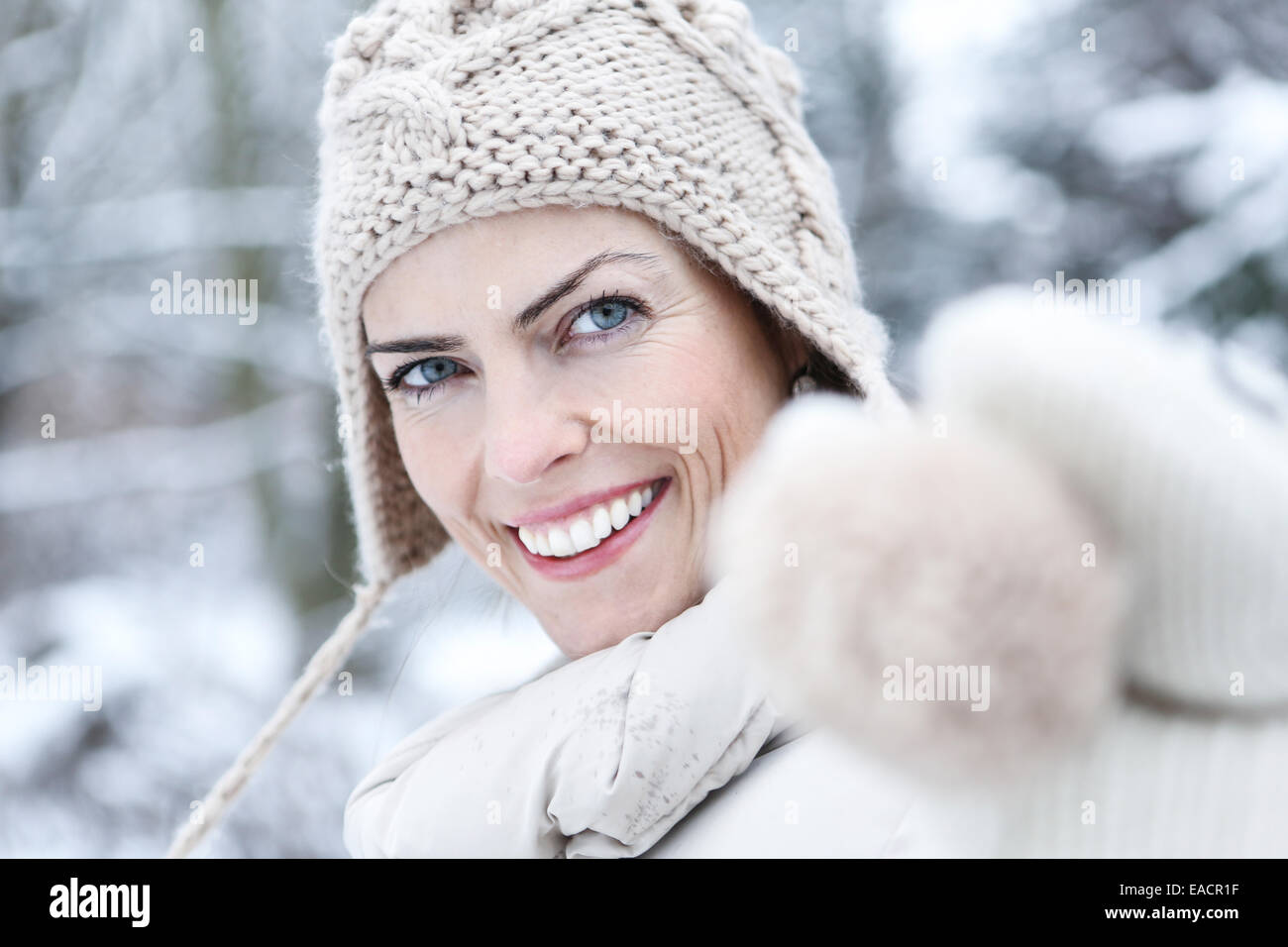Attraktive Frau mit Mütze lächelnd im winter Stockfoto