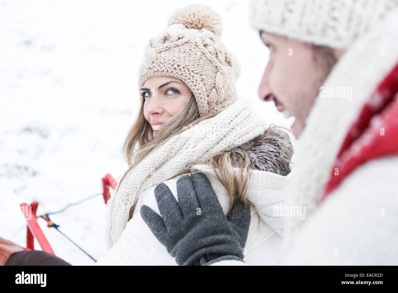 Glückliches Paar zusammen Rodeln im Winter durch Schnee Stockfoto